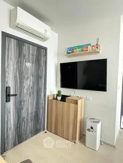 Modern living room with wall-mounted TV and air conditioning unit, featuring sleek wooden accents.