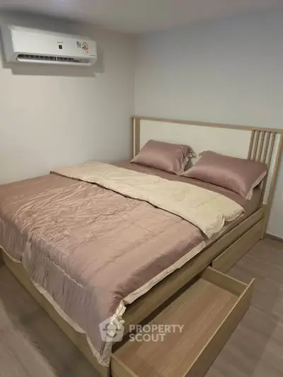 Cozy bedroom with modern air conditioning and elegant bedding in a stylish apartment.