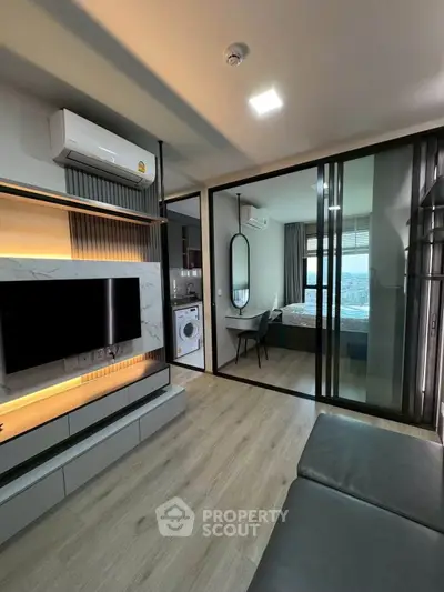 Modern apartment interior with sleek living room and bedroom view, featuring stylish decor and natural light.