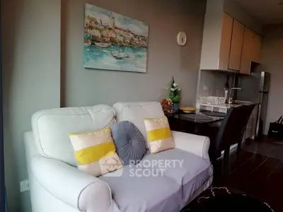 Cozy living room with modern decor and compact kitchen in open layout apartment.