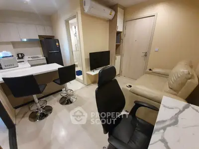 Modern apartment interior with open kitchen and cozy living area, featuring sleek furniture and contemporary design.
