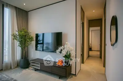 Modern living room with sleek TV setup and elegant decor in a high-rise apartment.