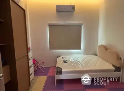 Cozy bedroom with air conditioning and playful flooring, perfect for a child's room.