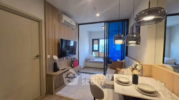 Modern open-layout living room with dining area and stylish lighting in a cozy apartment.