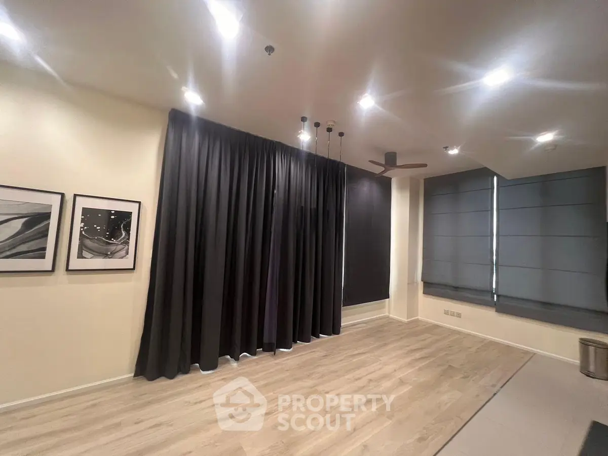 Spacious modern living room with elegant lighting and floor-to-ceiling curtains.