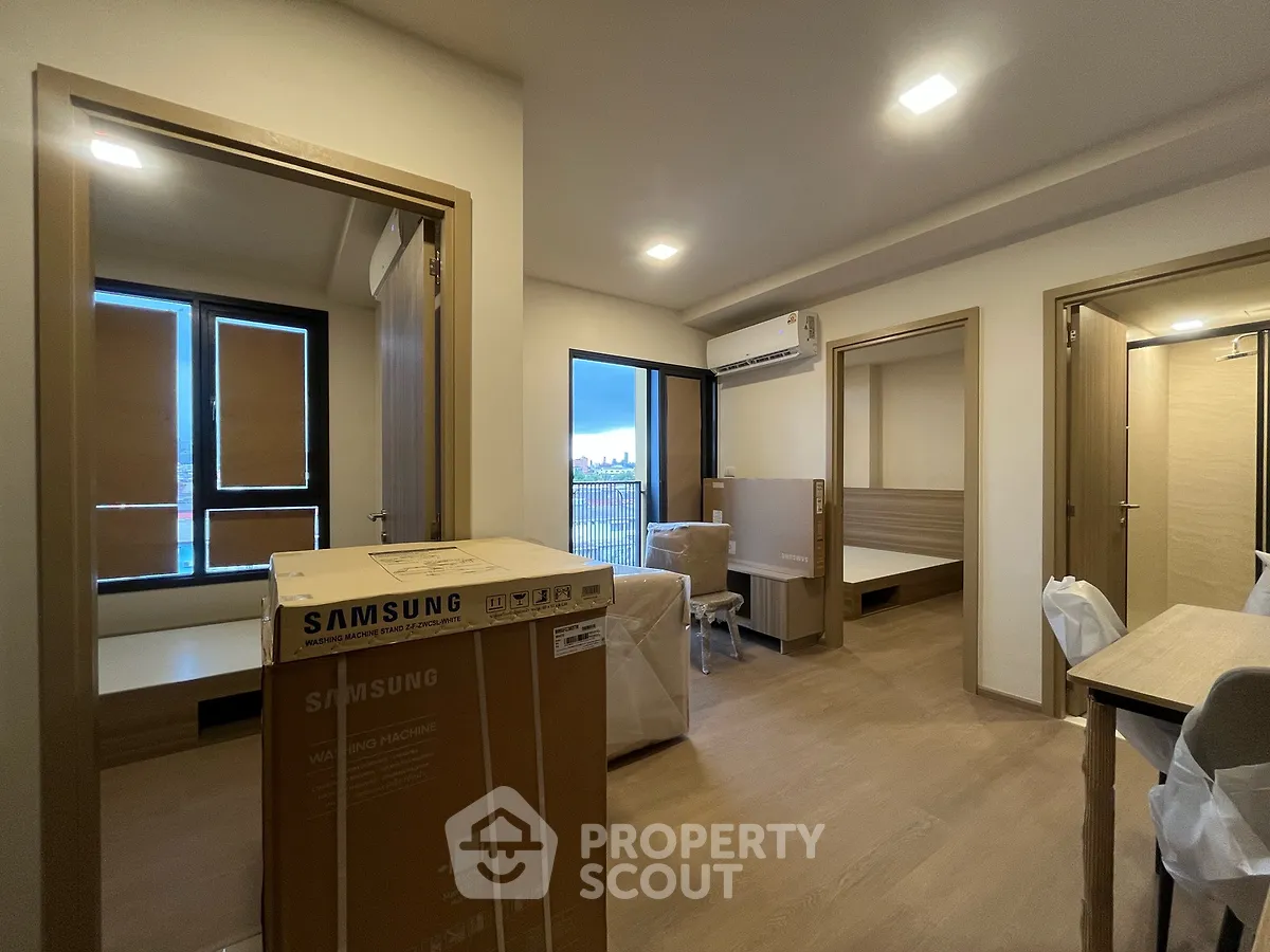 Modern apartment interior with natural light, featuring a Samsung washing machine and stylish furnishings.
