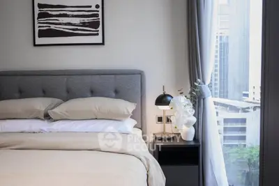 Modern bedroom with stylish decor and city view, featuring a cozy bed and elegant nightstand.