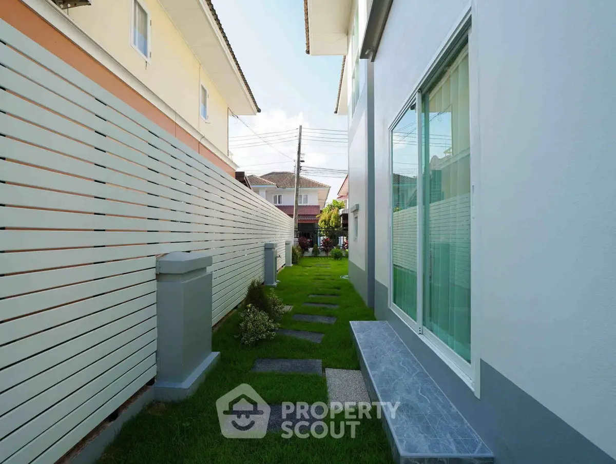 Charming residential exterior with lush green pathway and modern architecture.