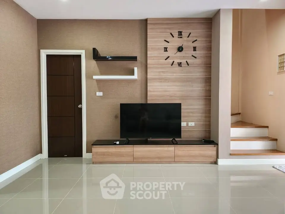 Modern living room with wall-mounted TV and stylish clock