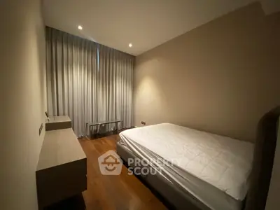 Cozy bedroom with elegant wooden flooring and soft lighting, perfect for relaxation.