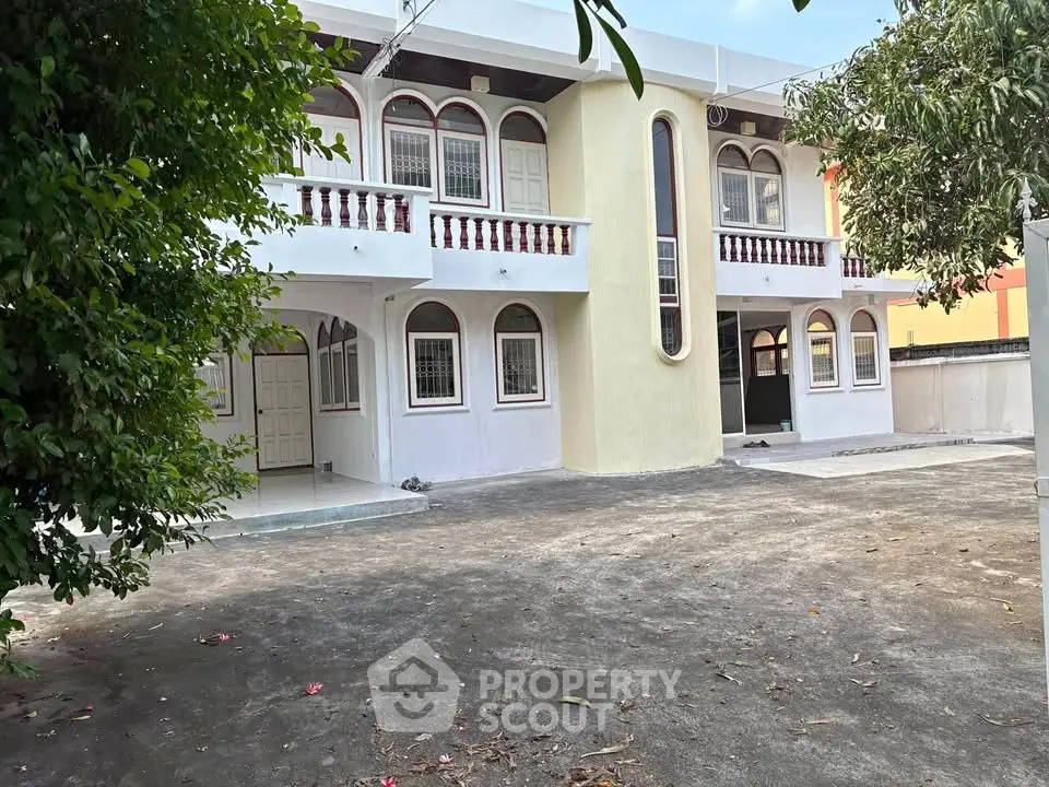 Spacious two-story house with elegant arches and ample outdoor space, perfect for family living.