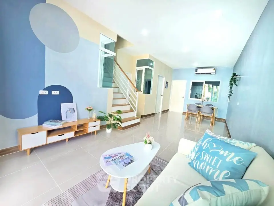 Modern living room with stylish decor and open layout, featuring a cozy sofa and elegant dining area.