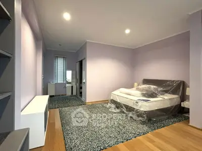 Spacious bedroom with modern decor and natural light, featuring a cozy bed and stylish flooring.