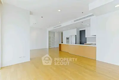 Spacious open-plan kitchen and living area with modern design and wooden flooring.