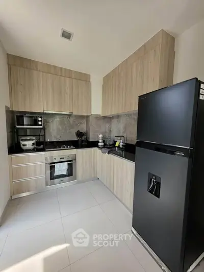 Modern kitchen with sleek black appliances and wooden cabinetry