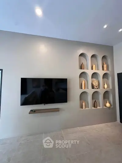 Modern living room with wall-mounted TV and decorative alcoves