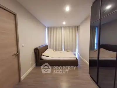 Spacious modern bedroom with sleek mirrored wardrobe and cozy bed.