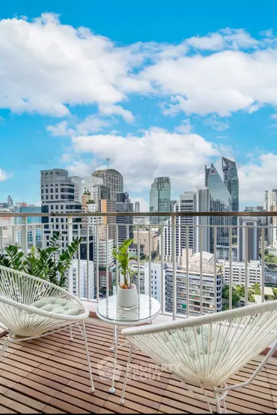 Stunning city view from a modern balcony with stylish seating and plants.