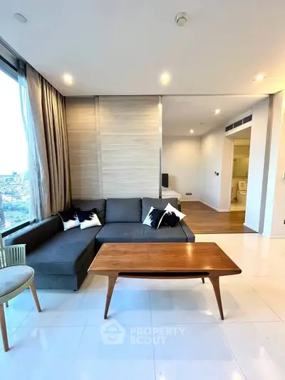 Modern living room with stylish furniture and large windows offering city views.