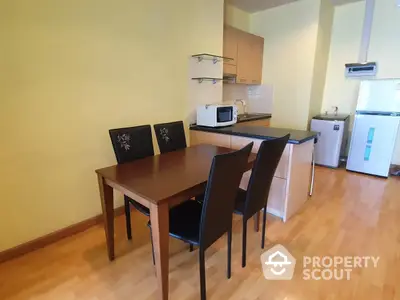 Cozy kitchen with modern appliances and a wooden dining set, featuring ample natural light and a practical layout for comfortable living.