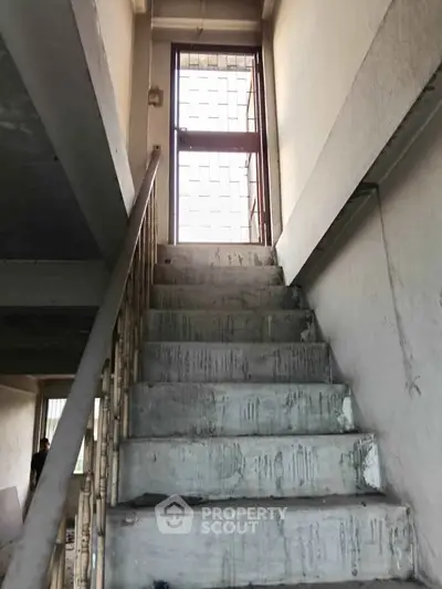 Staircase leading to a bright exit in a residential building