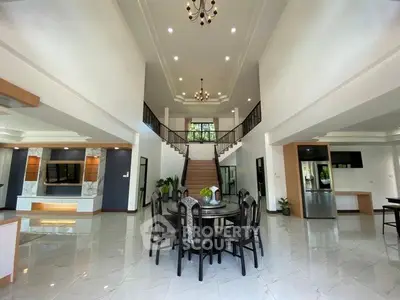 Luxurious open-plan living room with high ceilings and elegant staircase