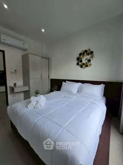 Cozy bedroom with modern decor and air conditioning, perfect for relaxation.