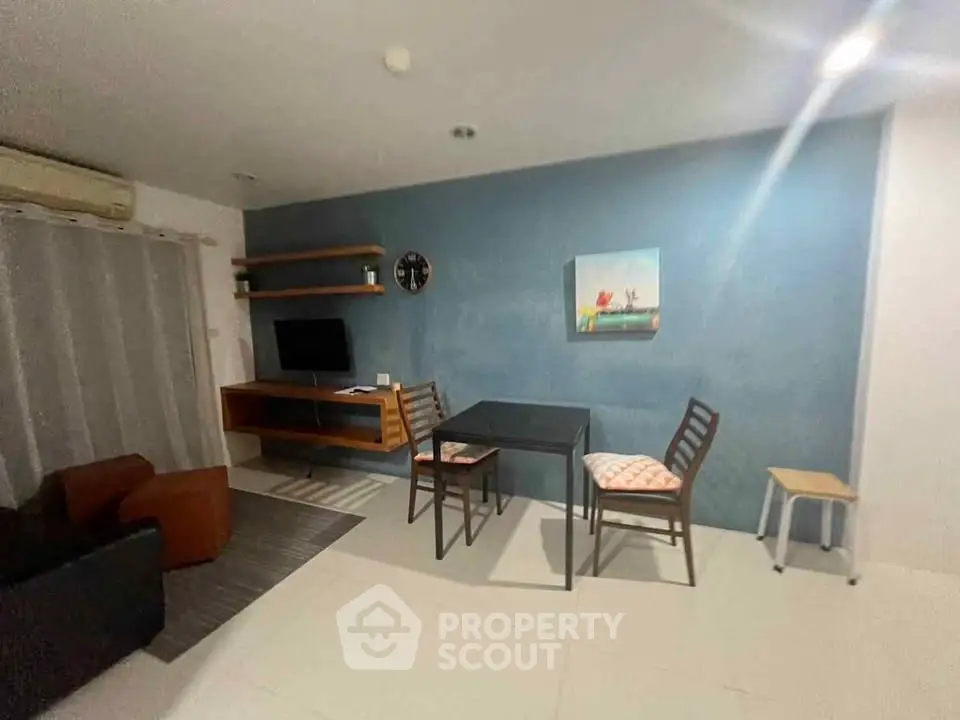 Cozy living room with modern decor and wall-mounted TV, perfect for relaxation.