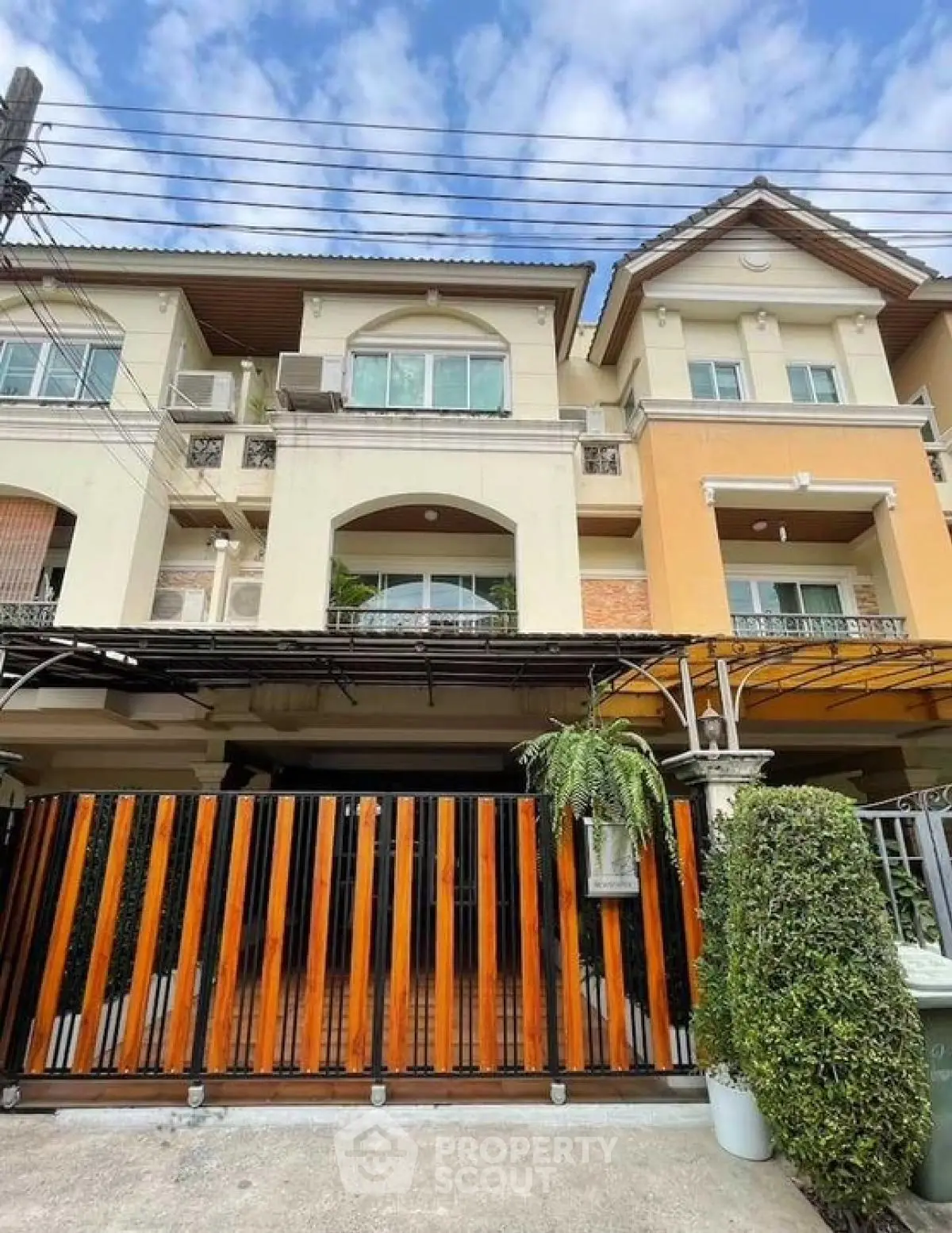 Charming townhouse exterior with modern design and lush greenery