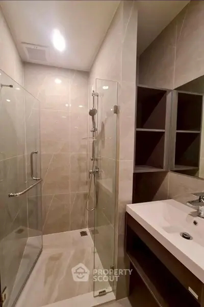 Modern bathroom with glass shower and sleek vanity in a contemporary home.