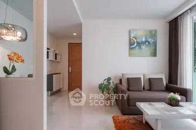 Modern living room with cozy sofa, stylish decor, and natural light from large window.