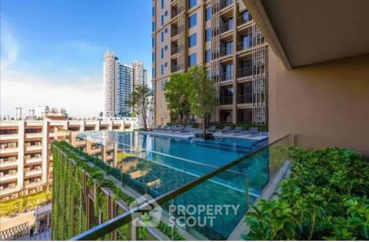 Luxurious high-rise building with stunning rooftop pool and lush greenery.