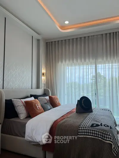 Luxurious bedroom with elegant decor and large window offering natural light.