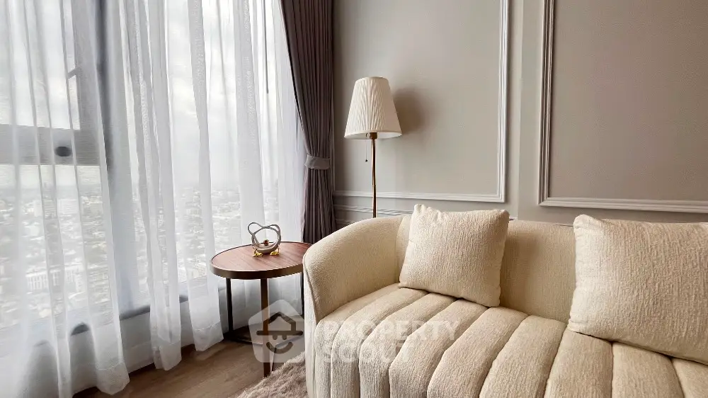 Elegant living room with plush sofa and panoramic city view through large windows.