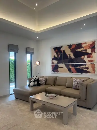 Elegant living room with modern art and plush sofa, perfect for relaxation.