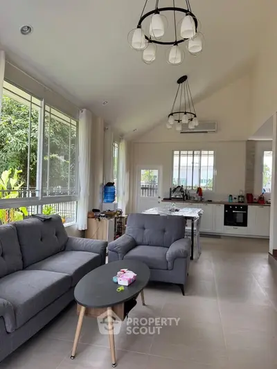 Spacious living room with modern furniture and large windows offering garden views.