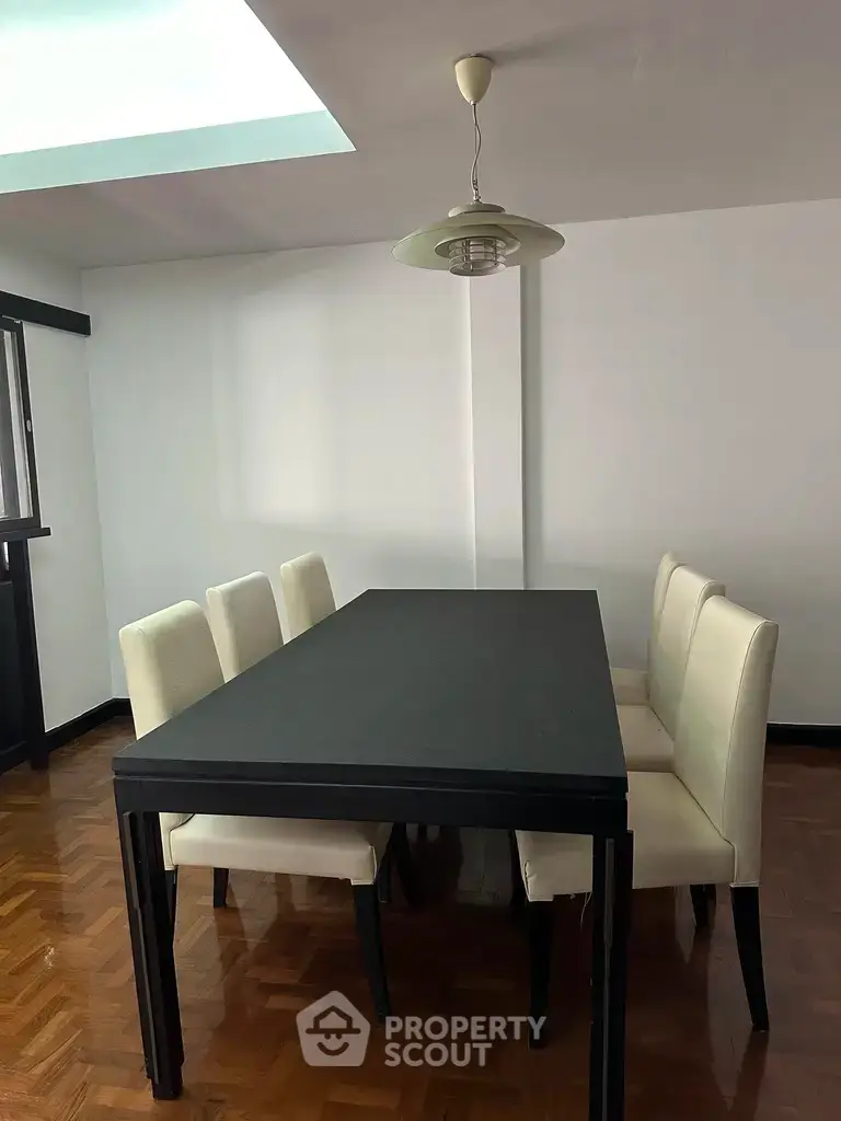 Elegant dining area with modern black table and white chairs, perfect for stylish gatherings.