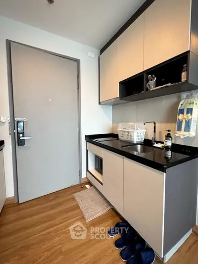 Modern kitchen with sleek cabinets and wooden flooring