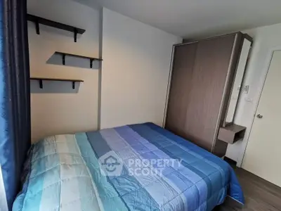 Cozy bedroom with modern wardrobe and wall shelves, perfect for urban living.