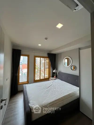 Modern bedroom with large windows and stylish decor in urban apartment