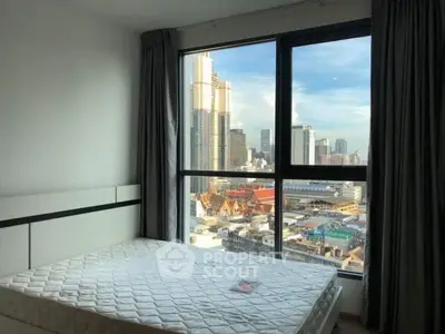 Spacious bedroom with stunning city view from large window in modern apartment.