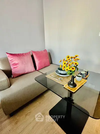 Cozy living room with modern sofa and elegant glass table, perfect for relaxation.