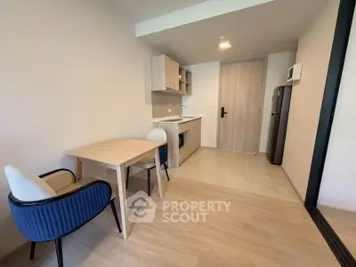 Modern minimalist kitchen and dining area with light wood finishes and sleek design.