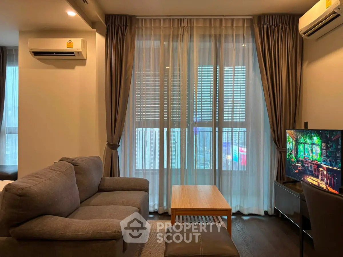Modern living room with cozy sofa, large window, and air conditioning unit