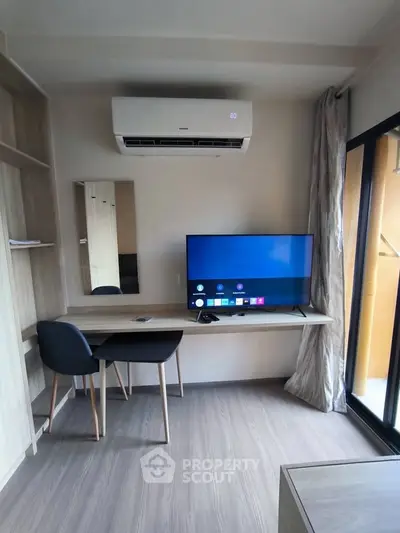 Modern study area with desk, chair, and TV under air conditioning unit.