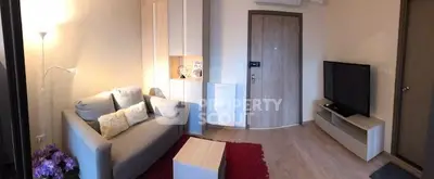 Cozy living room with modern decor, featuring a comfortable sofa, flat-screen TV, and stylish wooden flooring.