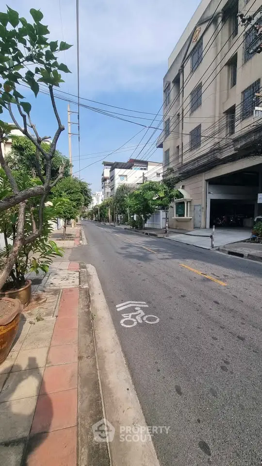 Quiet urban street with residential buildings and bike lane, ideal for city living.
