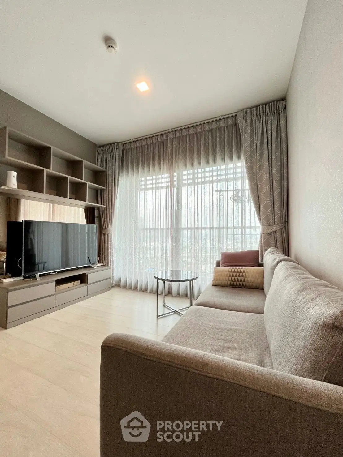 Spacious living room with modern decor and large window for natural light