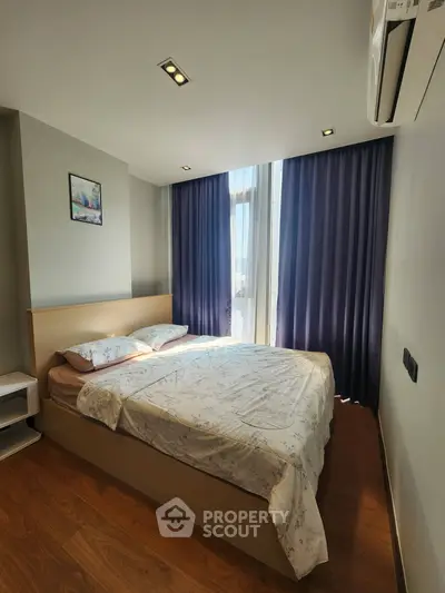 Cozy bedroom with natural light and modern decor, featuring a comfortable bed and elegant curtains.