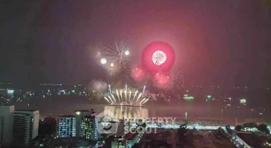 Spectacular cityscape with vibrant fireworks illuminating the night sky over a waterfront.